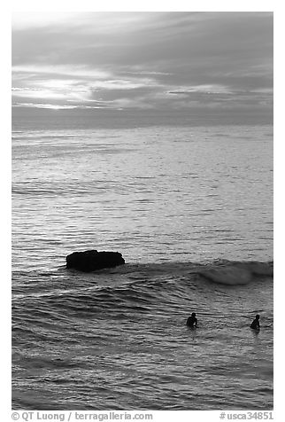 Surfers and rock at sunset. Santa Cruz, California, USA (black and white)