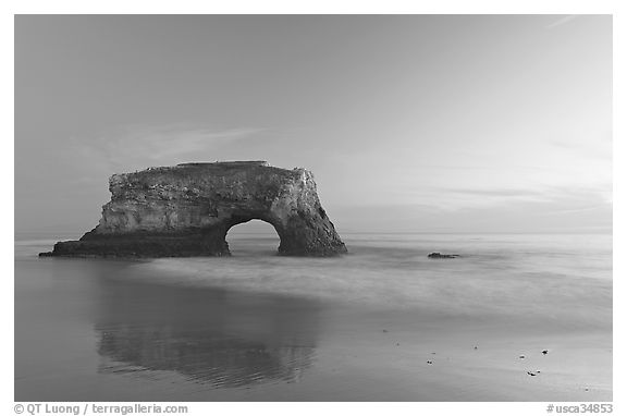 Sea arch and reflection, Natural Bridges State Park, dusk. Santa Cruz, California, USA