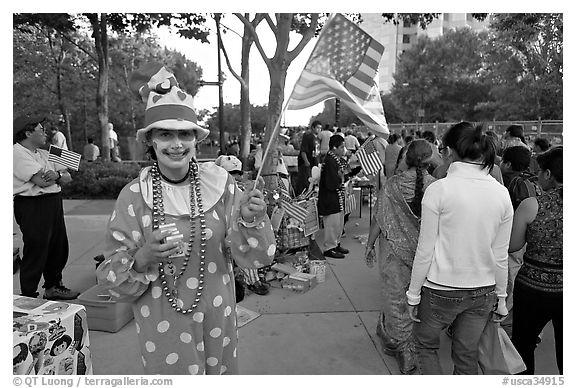 Woman in clown costume waiving American Flag, Independence Day. San Jose, California, USA (black and white)