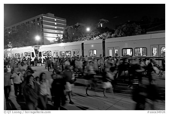 Crowds and light rail on San Carlos Avenue at night, Independence Day. San Jose, California, USA