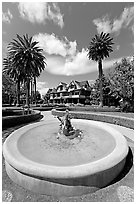 Wide view of fountain and mansion. Winchester Mystery House, San Jose, California, USA (black and white)