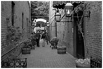Couple walking in an alley of brick walls, San Pedro Square. San Jose, California, USA ( black and white)
