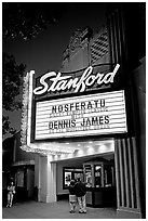 Couple standing in front of Stanford Theatre at night. Palo Alto,  California, USA (black and white)