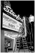 Woman on ladder arranging sign letters, Stanford Theater. Palo Alto,  California, USA (black and white)