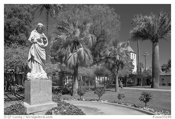 Statue, palm trees, and mission, Santa Clara University. Santa Clara,  California, USA (black and white)