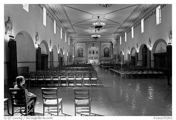 Woman sitting in chapel, Mission Santa Clara de Asis. Santa Clara,  California, USA