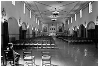 Woman sitting in chapel, Mission Santa Clara de Asis. Santa Clara,  California, USA (black and white)