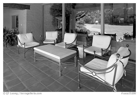 Chairs and coffee table on porch, Sunset gardens reflected. Menlo Park,  California, USA (black and white)