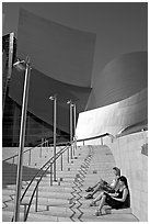 Women sunning on the steps of the entrance of the Walt Disney Concert Hall. Los Angeles, California, USA (black and white)