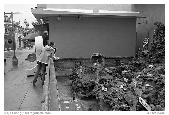 Woman at wishing well fountain, Chinatown. Los Angeles, California, USA