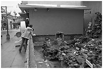 Woman at wishing well fountain, Chinatown. Los Angeles, California, USA (black and white)