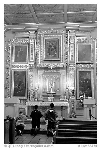 Prayer at altar in Mission Chapel. Los Angeles, California, USA (black and white)