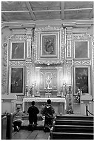 Prayer at altar in Mission Chapel. Los Angeles, California, USA (black and white)