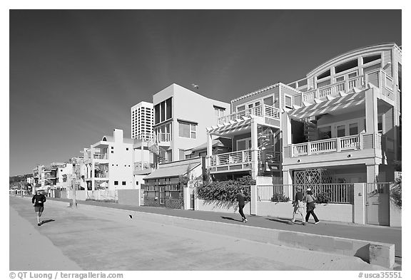 People jogging and strolling on beach promenade. Santa Monica, Los Angeles, California, USA (black and white)