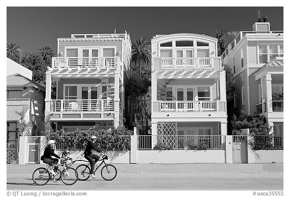 Family cycling in front of colorful beach houses. Santa Monica, Los Angeles, California, USA (black and white)