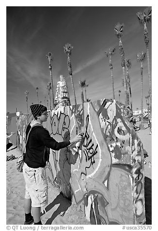 Young man making graffiti on a wall. Venice, Los Angeles, California, USA (black and white)