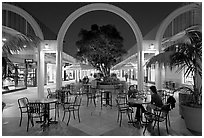 Sitting at outdoor table at night, Stanford Shopping Center. Stanford University, California, USA (black and white)