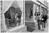 Women walking by storefront on Main Street. Half Moon Bay, California, USA (black and white)