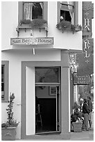 Entrance of historic San Benito House, with couple looking. Half Moon Bay, California, USA (black and white)