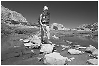 Woman crossing stream on rocks, John Muir Wilderness. California, USA ( black and white)