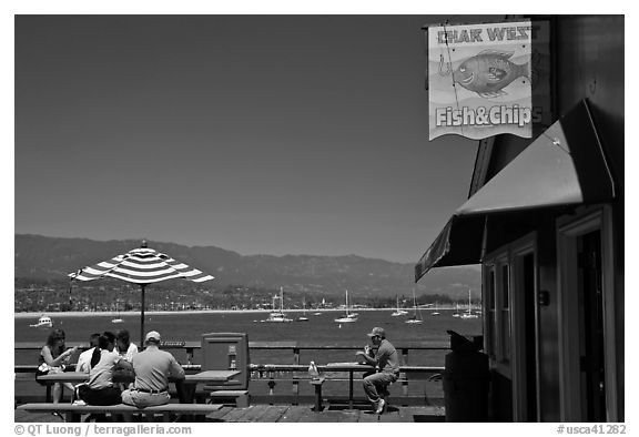 People eating with yachts and beach in background. Santa Barbara, California, USA