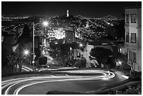 Sharp switchbacks on Russian Hill with Telegraph Hill in the background, night. San Francisco, California, USA (black and white)