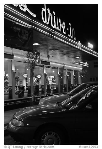 Neon lights of Mels drive-in reflected on parked cars. San Francisco, California, USA (black and white)