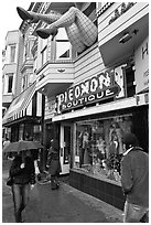 Woman passing with unbrella below giant legs. San Francisco, California, USA ( black and white)