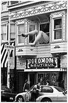 Woman exiting car below women legs with stockings. San Francisco, California, USA (black and white)