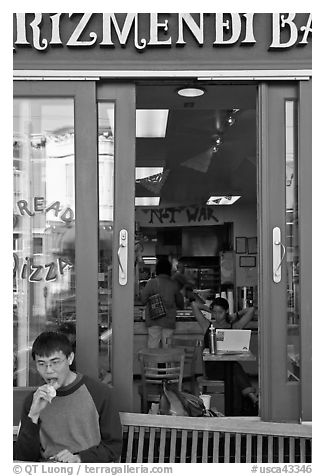 Man biting pizza outside pizzaria, Haight-Ashbury district. San Francisco, California, USA (black and white)