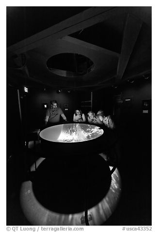 Tourists look at moving image of ocean inside the Camera Obscura, Cliff House. San Francisco, California, USA (black and white)