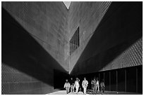 Tourists walking out of a striking corner of De Young Museum. San Francisco, California, USA ( black and white)