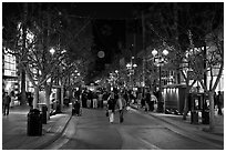 Couple walking on pedestrian Third Street by night. Santa Monica, Los Angeles, California, USA (black and white)