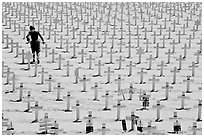 Boy in beachwear walking amongst crosses. Santa Monica, Los Angeles, California, USA ( black and white)