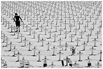 Boy in beachwear walking amongst crosses. Santa Monica, Los Angeles, California, USA (black and white)