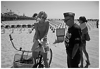 Veteran for peace conversing with woman on bicycle. Santa Monica, Los Angeles, California, USA (black and white)