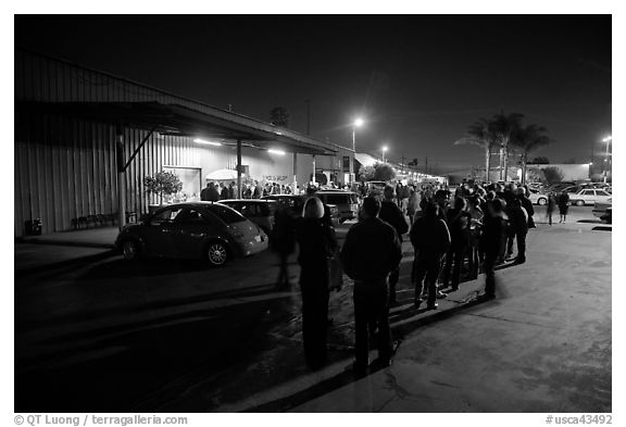 People lining up to enter a gallery at night, Bergamot Station. Santa Monica, Los Angeles, California, USA (black and white)