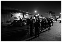 People lining up to enter a gallery at night, Bergamot Station. Santa Monica, Los Angeles, California, USA ( black and white)