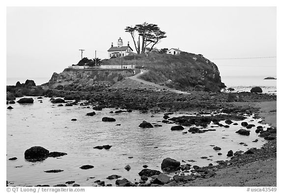 Rocky mound and lighthouse, Crescent City. California, USA (black and white)