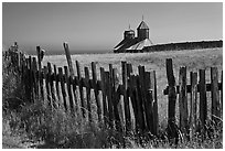 Fences, summer grass and chapel towers, Fort Ross. Sonoma Coast, California, USA ( black and white)