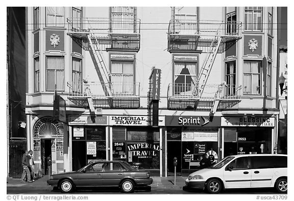 Buildings, cars, and sidewalk, Mission Street, Mission District. San Francisco, California, USA