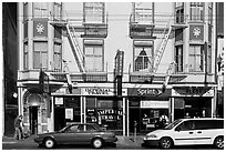 Buildings, cars, and sidewalk, Mission Street, Mission District. San Francisco, California, USA (black and white)