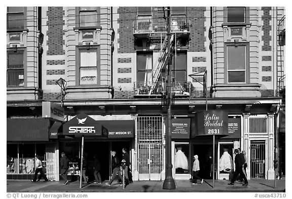 People walking on sidewalk, Mission Street, Mission District. San Francisco, California, USA (black and white)