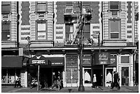 People walking on sidewalk, Mission Street, Mission District. San Francisco, California, USA (black and white)