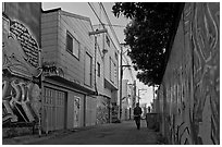 Man walking in alley, Mission District. San Francisco, California, USA (black and white)