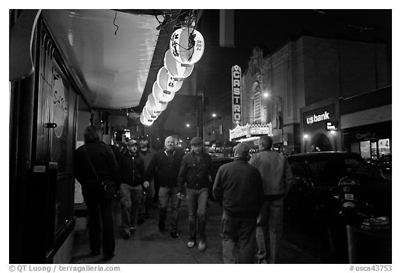 Men walking on sidewalk, Castro street at night. San Francisco, California, USA