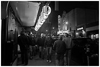 Men walking on sidewalk, Castro street at night. San Francisco, California, USA (black and white)