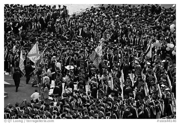 Academic flags exit amongst crow of graduates after commencement ceremony. Stanford University, California, USA