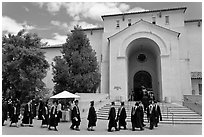 Graduates walking single file into Memorial auditorium. Stanford University, California, USA (black and white)