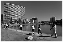 People strolling around 3.5 mile path around Lake Merritt. Oakland, California, USA (black and white)
